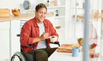 person in a wheelchair holding a bowl of food