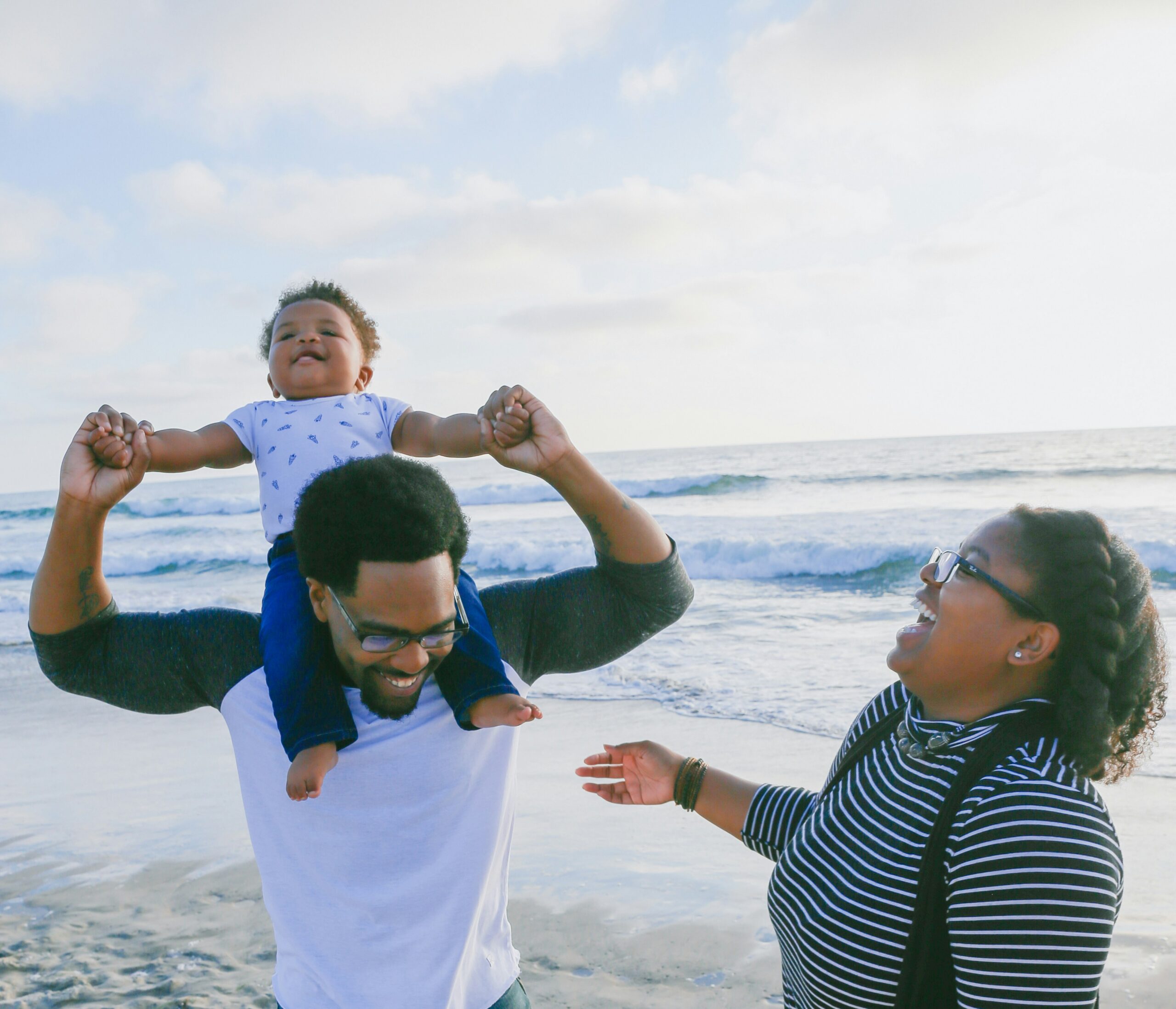 family on the beach. child on dads shoulders