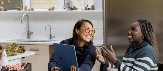 two women laughing with a laptop
