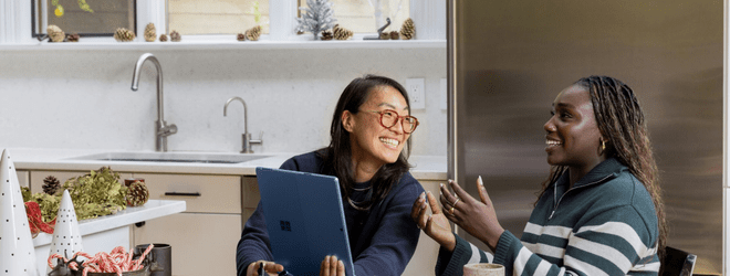two women laughing with a laptop