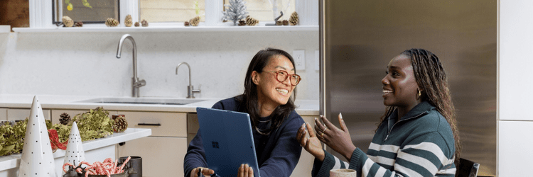 two women laughing with a laptop